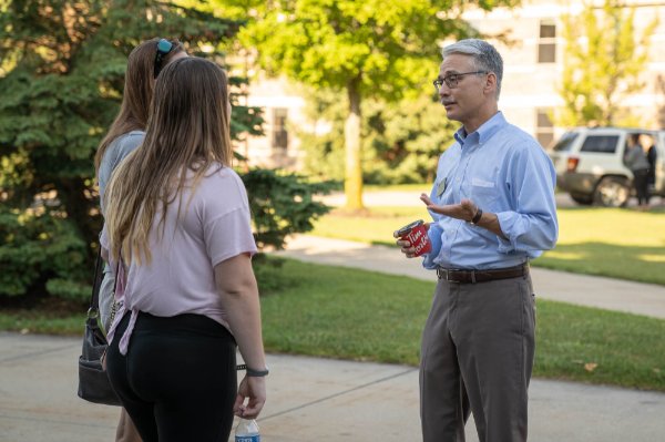 Loren Rullman, GVSU's dean of students, talks to two students during move-in