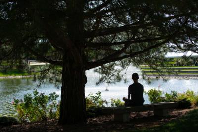 A G-V-S-U student sits by the Zumberge Pond on the Allendale Campus.