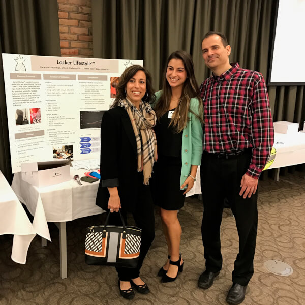 three people standing in front of poster