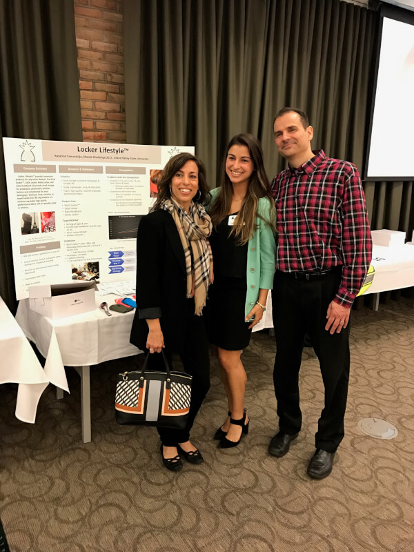 three people standing in front of poster