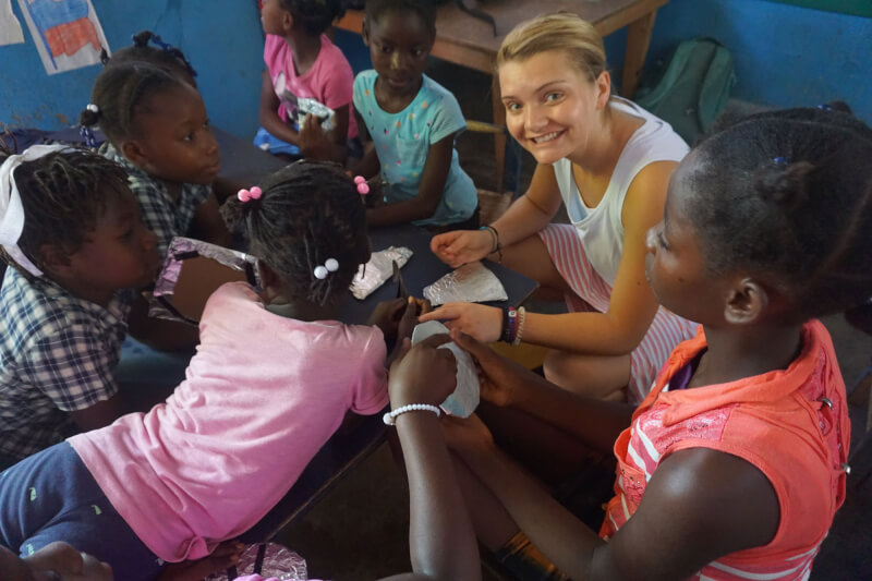 GVSU student Skyler Wickert working with students in Haiti during an art workshop.