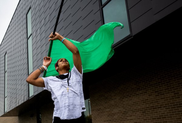  A person waves a green flag over their head.