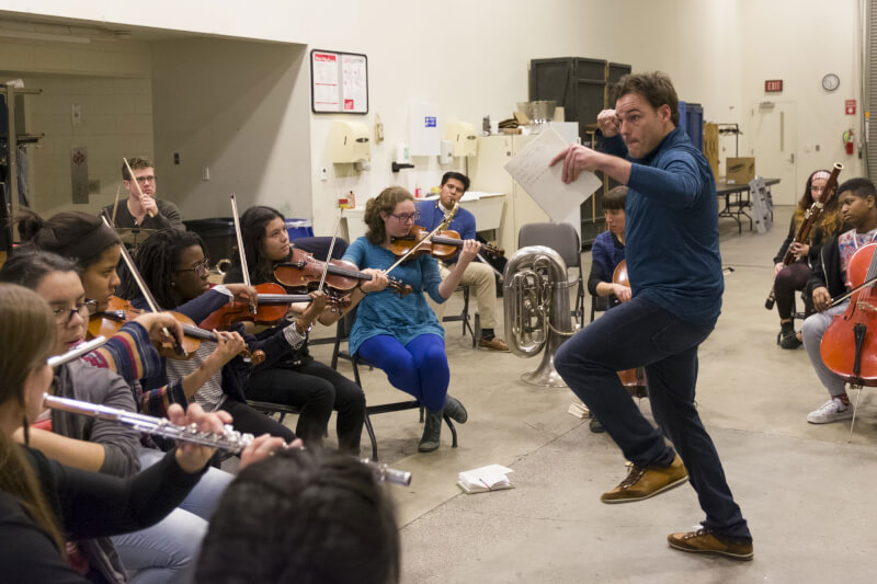 Margaret Hawley-Lowry (center) plays the violin during a rehearsal.