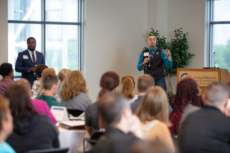 man with microphone talking to audience