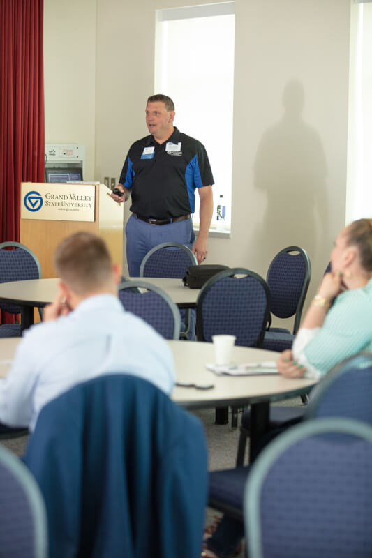 man giving presentation in front of projector screen
