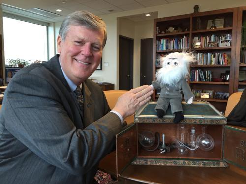 President Thomas J. Haas celebrates the upcoming events with a Charles Darwin toy. Activities will run February 11-12.