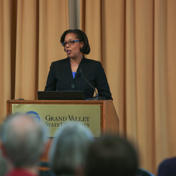 woman stands behind podium