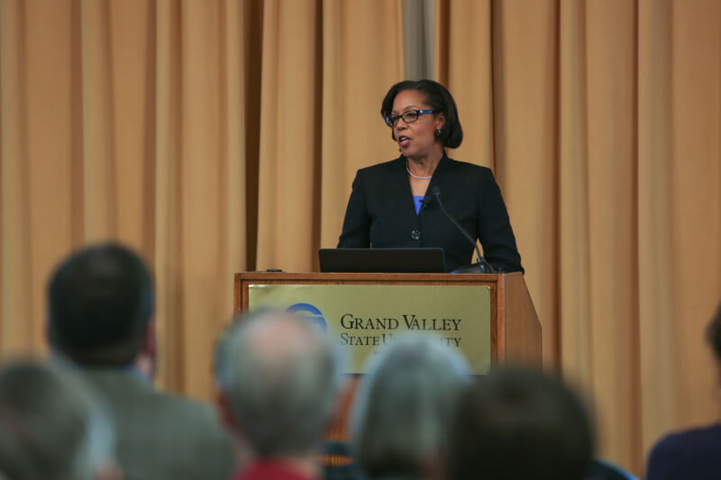 woman stands behind podium