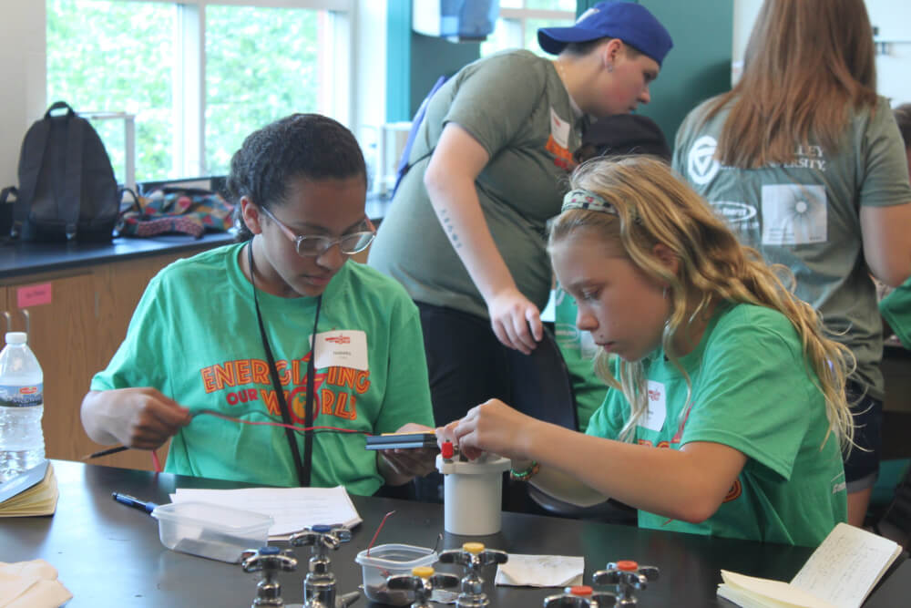 Campers test metals in vinegar batteries.