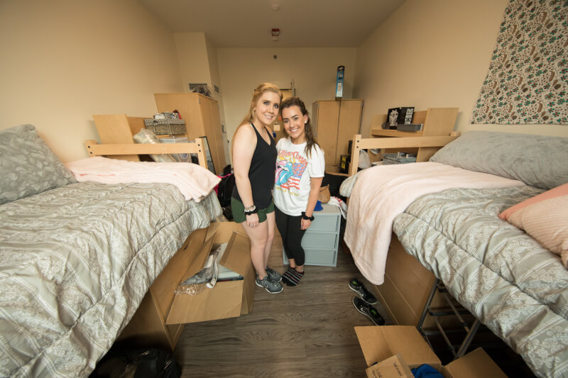  Two female roommate hugging in dorm room