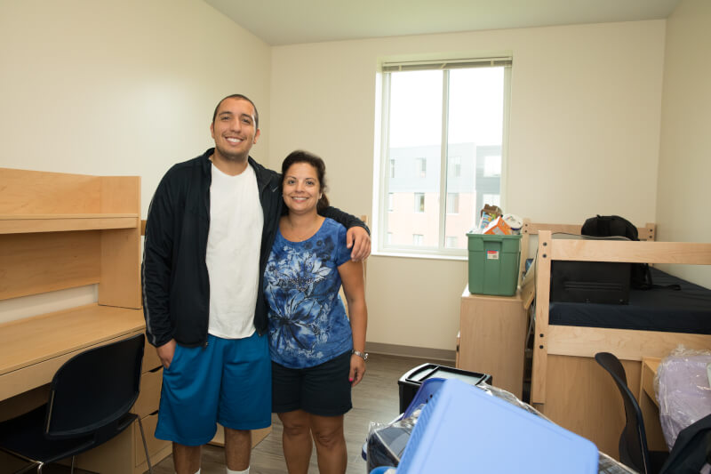  Mother and son hugging in dorm room