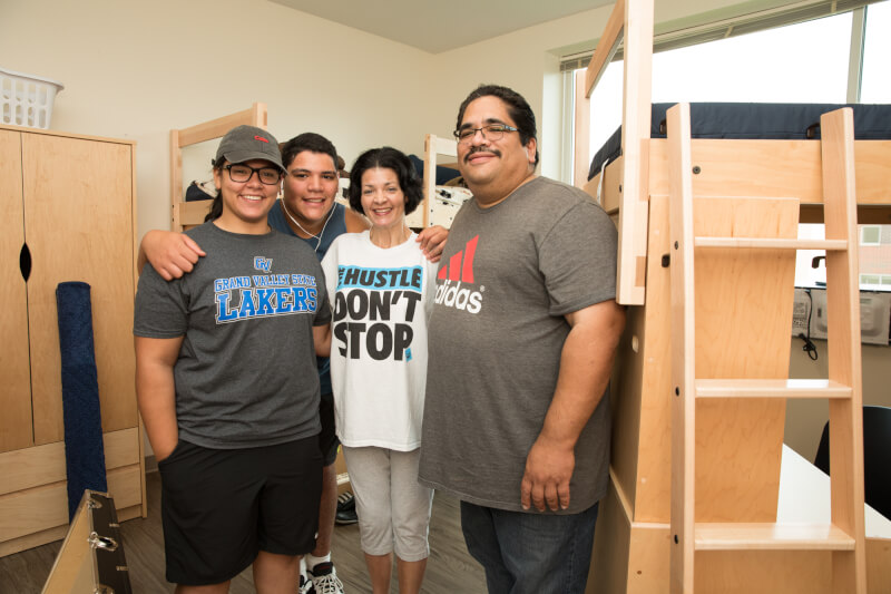  Four family members hugging in dorm room