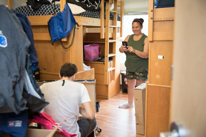 Mother and son setting up a dorm room