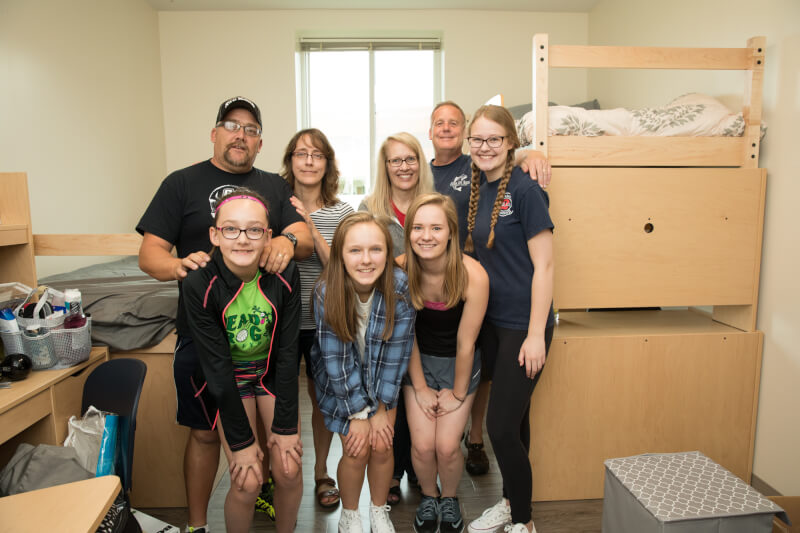  Eight family members hugging in dorm room