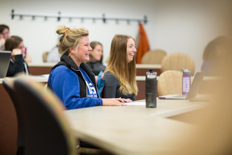 A photo of students smiling in class.