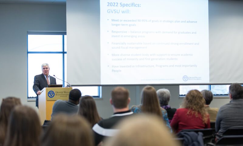 Man at podium in front of screen