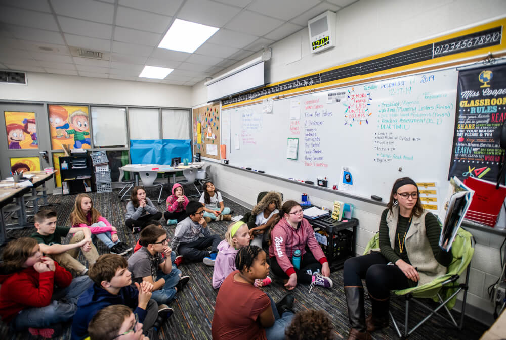 A photo of alumna Payton Cooper reads to her fourth grade class.