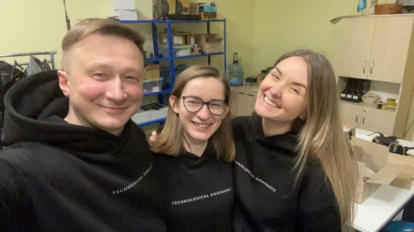 three people wearing black sweatshirts with Technological Dominance printed on front