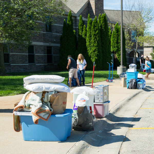 A picture of students carrying their belongings into a living center.