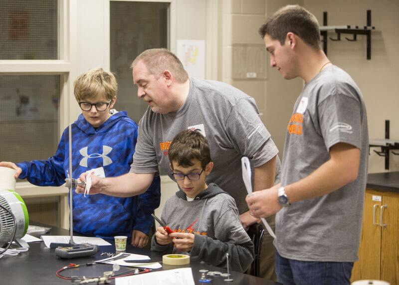 Students constructing wind turbines with the help of Richard Vallery, Physics Department chair. Photo by Steven Herppich.