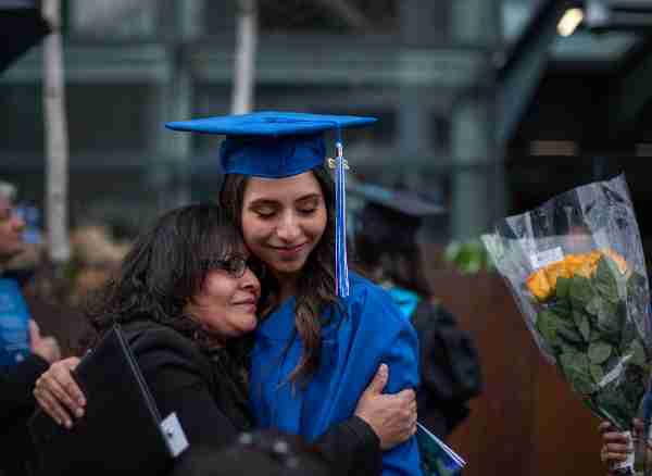 a graduate gets hugged by their supporter