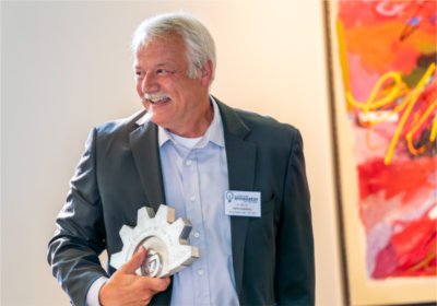 Keith Crandall holding the Innovator of the Year Trophy