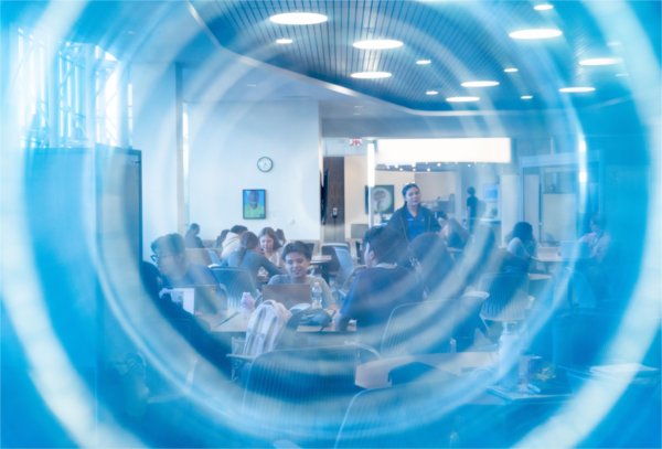 A study group of college students are seen through a blue circular shape. 