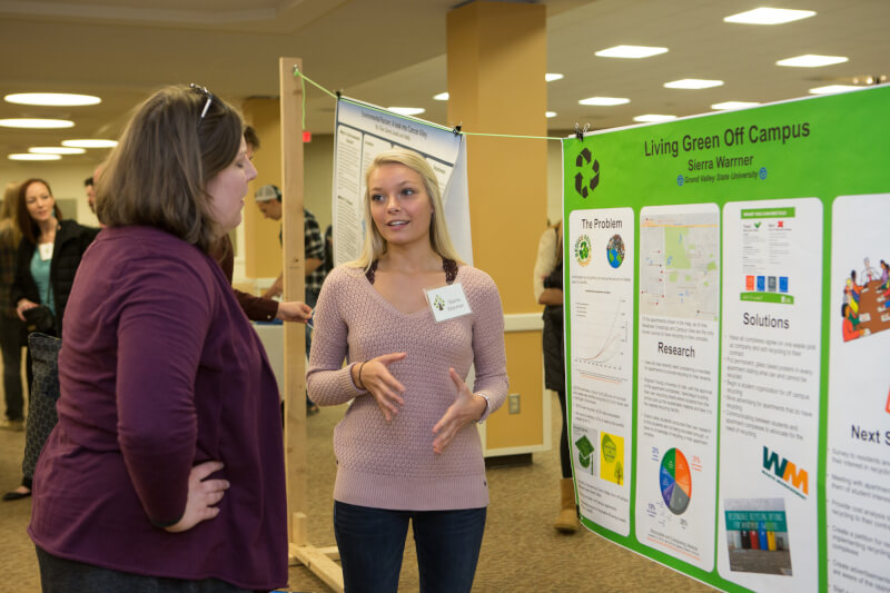 A student showcases her poster.