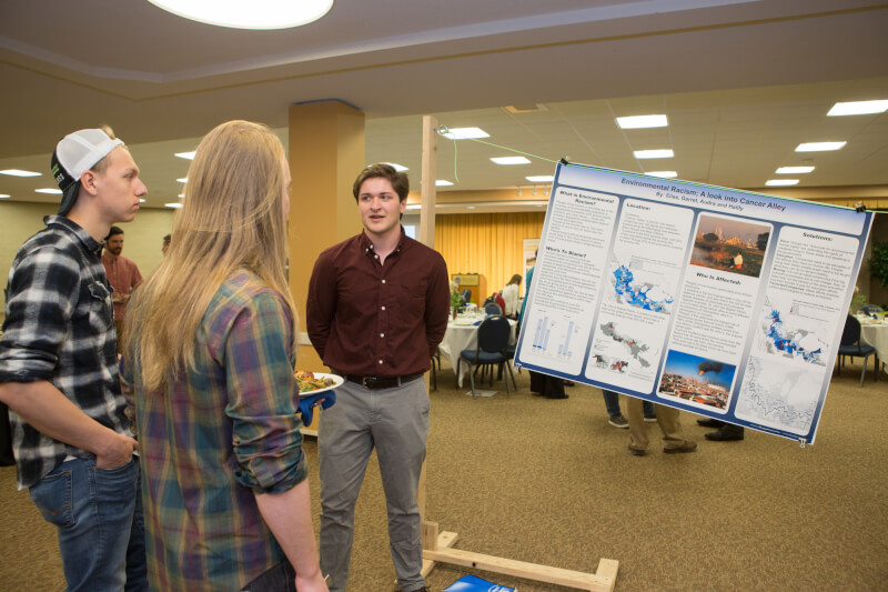 A student showcases her poster.