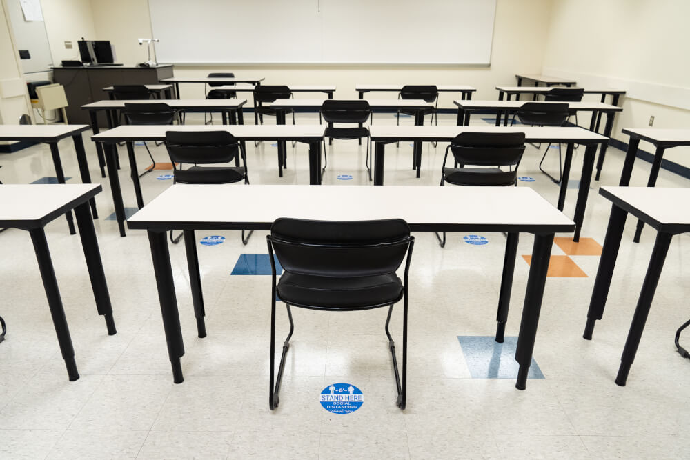 A photo of an empty classroom on GVSU's Allendale campus. Blue, circular floor stickers remind people to stay six feet apart and social distance to prevent the spread of COVID-19.