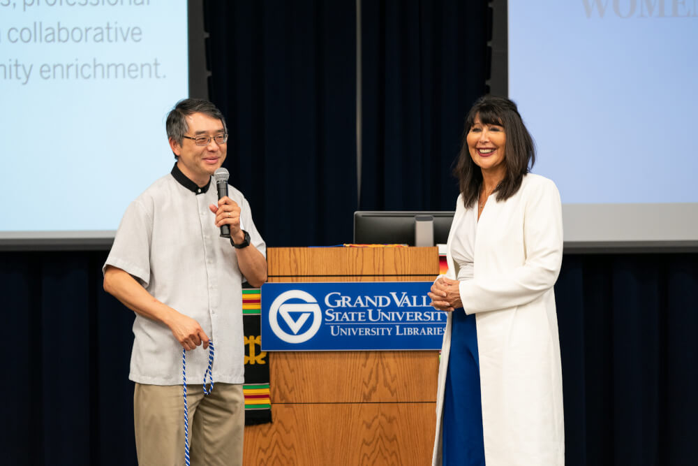 Kin Ma, from the Asian Faculty and Staff Association, presents President Mantella with a graduation cord.