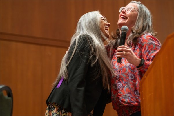 Lin Bardwell, left, and Jenny Hall-Jones share a laugh on stage prior to Treuer's presentation. 
