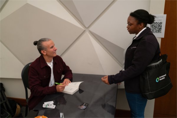 Treuer signs a copy of his book for an attendee.