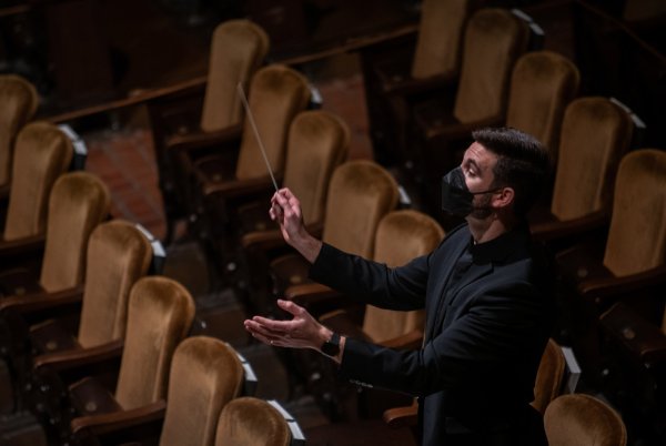 A conductor leads musicians