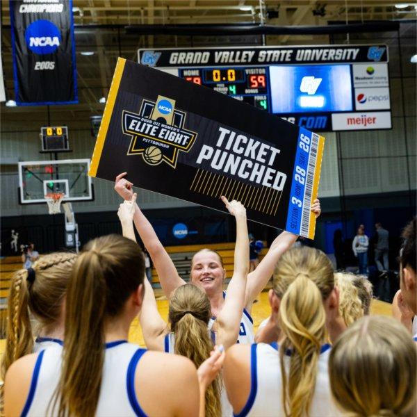 Paige VanStee, named the Midwest Regional&#8217;s Most Valuable Player, holds the Elite Eight ticket as teammates celebrate after a win over Northwood in the NCAA Division II Midwest Regional Championship on March 16 in the GVSU Fieldhouse Arena.