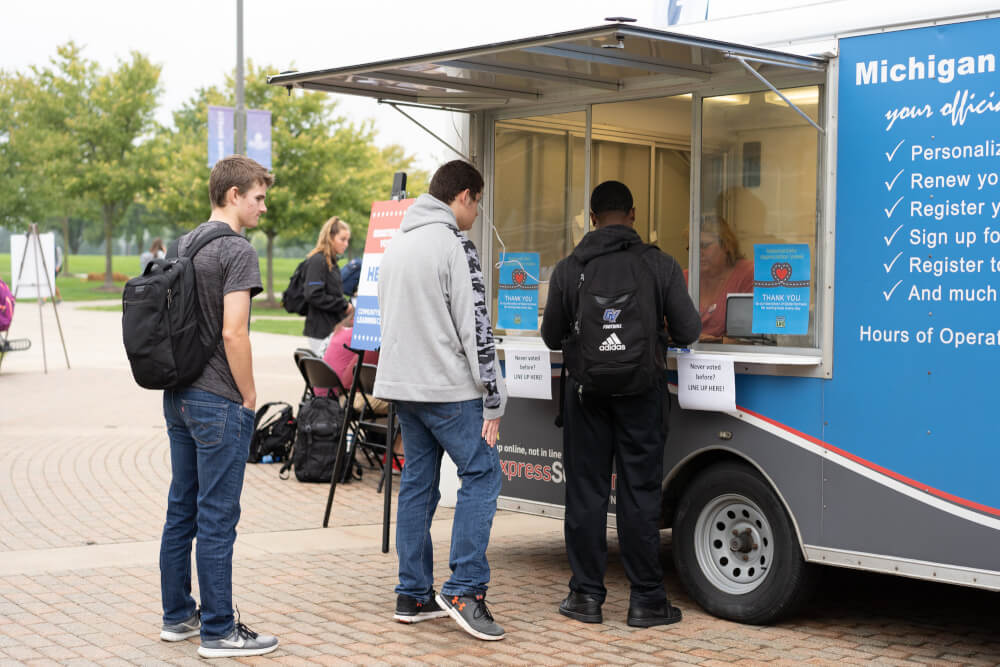 Students line up by the Michigan Secretary of State Mobile Unit on Grand Valley's Allendale Campus.