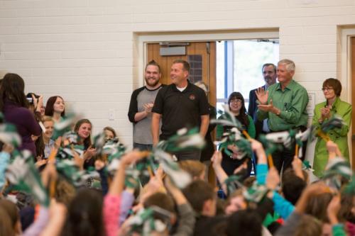 Shannon Brunink, center, is surprised by students at an assembly recognizing his award.