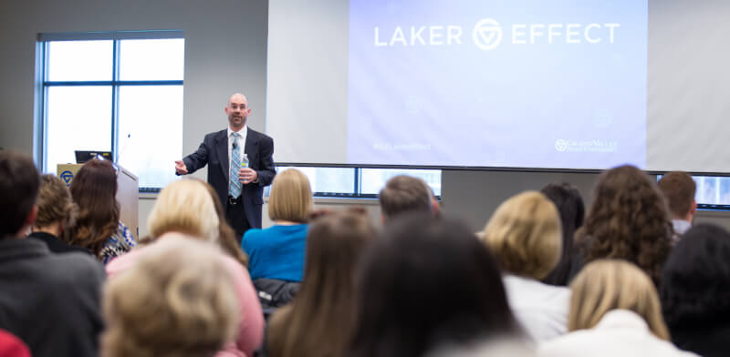 man in front of room speaking to audience