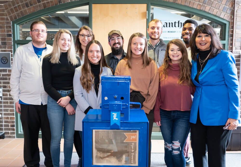 President Philomena V. Mantella with Grand Valley Lanthorn staff at a celebration for the newspaper's 100th newsstand.