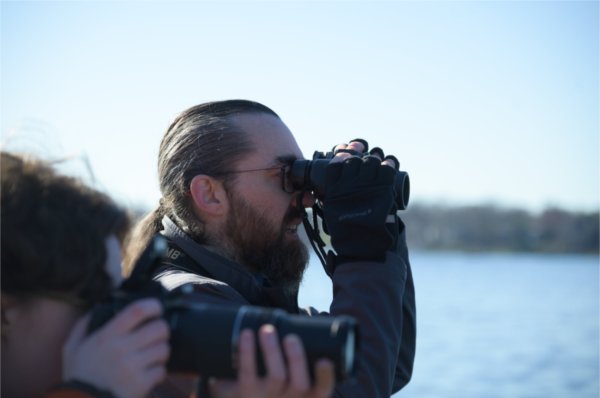 Casey Butler, a senior studying wildlife biology, looks through his binoculars to find birds on Reeds Lake April 11.

(Photo releases on file)