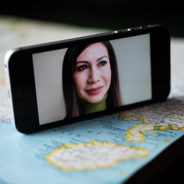 woman's face on cell phone, phone sitting on a map of China