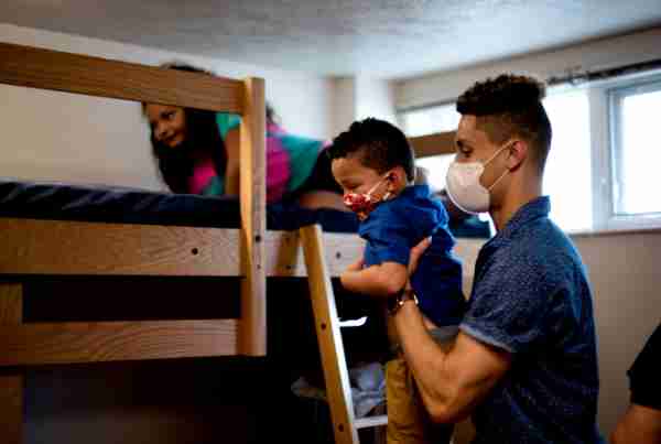 Garnett Woody, Jr., of Brooklyn, Mich., right, lifts his younger siblings, Futenma Woody, left, and Maxwell Woody, center, onto his bunk bed while moving into Kistler Living Center on August 24, 2020.