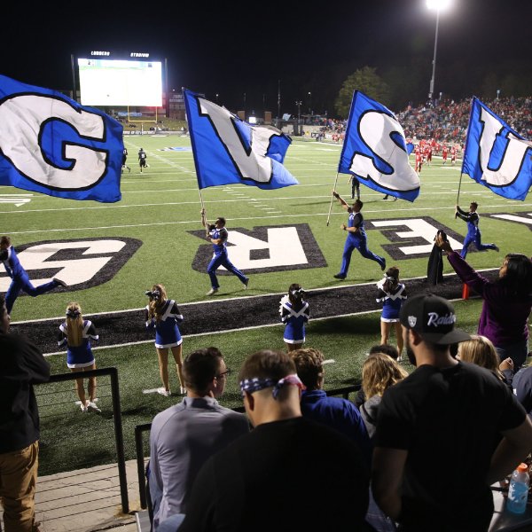 Cheerleaders wave flags during football game