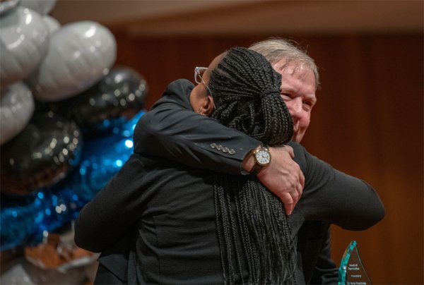Andy Beachnau, assistant vice president for Student Affairs, hugs Nykia Gaines, assistant vice president for Federal TRIO programs, left, after Gaines presented Beachnau with an appreciation award during the event.