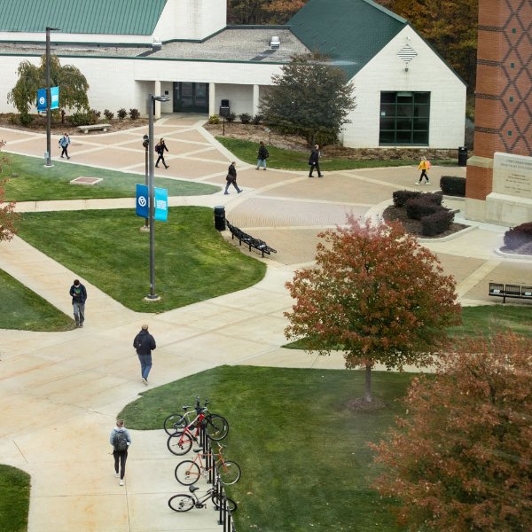 people walking on Allendale campus by carillon tower, lots of sidewalks pictured