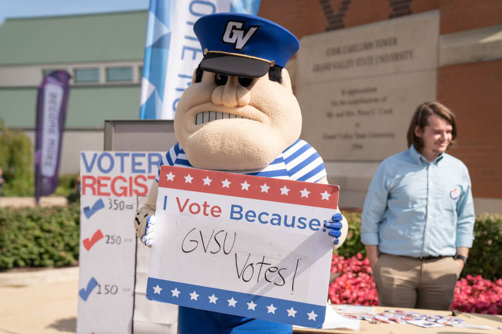 Louie the Laker poses with a GVSU Votes sign.