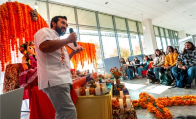 Rolando Mancera speaks in front of the Ofrenda at GVSU's D&#237;a de los Muertos celebration