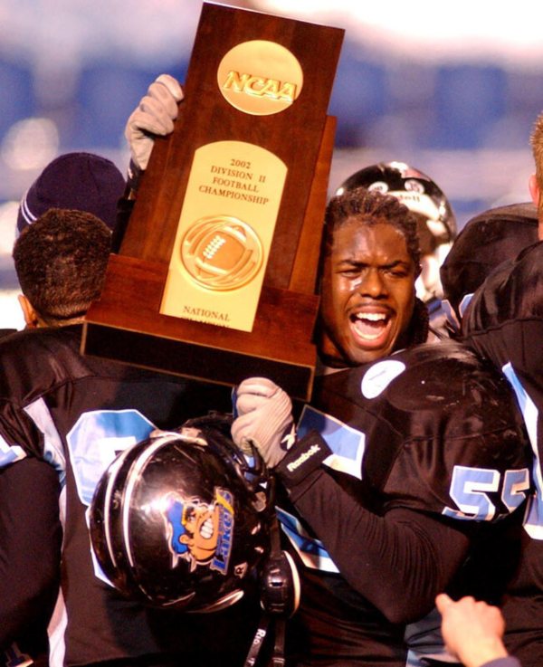football player holding NCAA Division II national championship trophy 