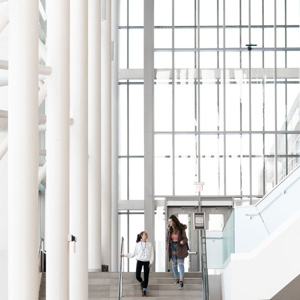 two students walk down the steps inside the Mary Idema Pew Library