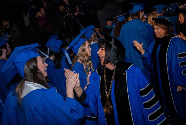 President Mantella high fives graduates after commencement.